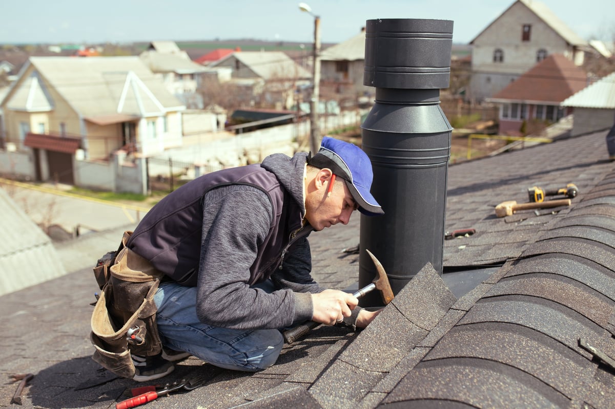 Professional roofer carefully installing roof tiles with expertise